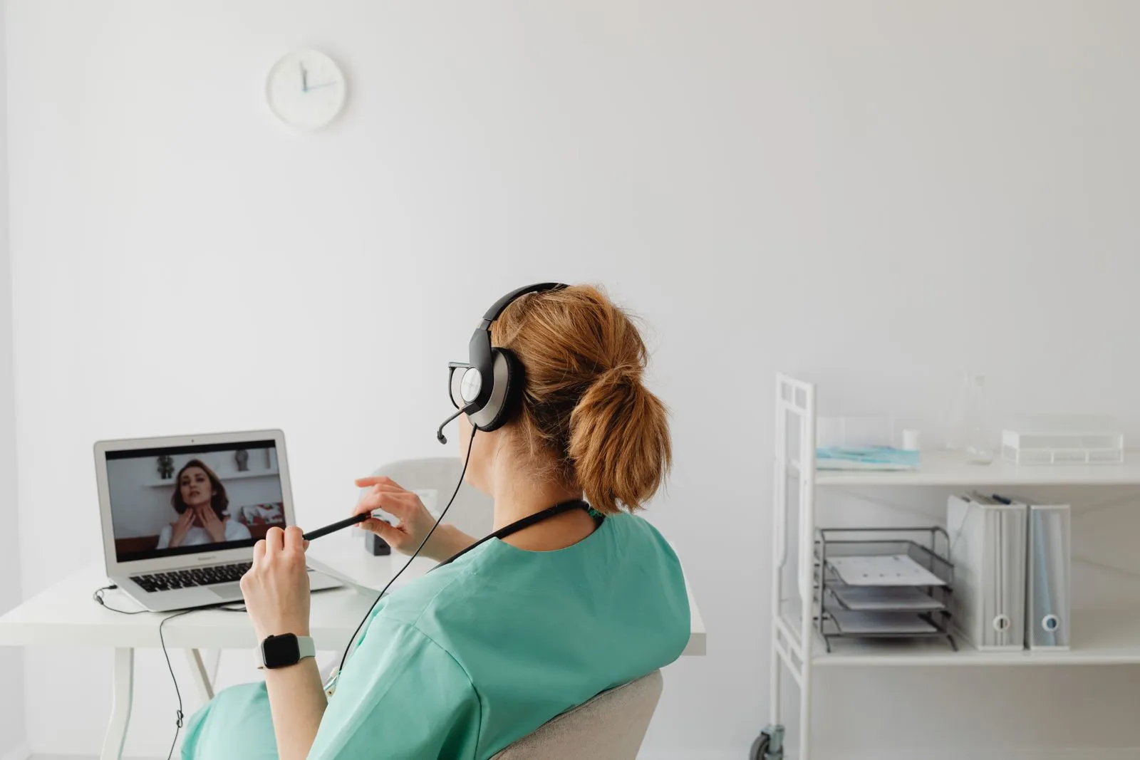 A clinician in scrubs leading an online coaching session over video call
