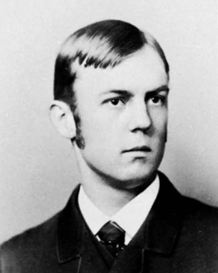 Black-and-white portrait of a young Charles Horton Cooley with neatly combed hair, in a dark suit and tie