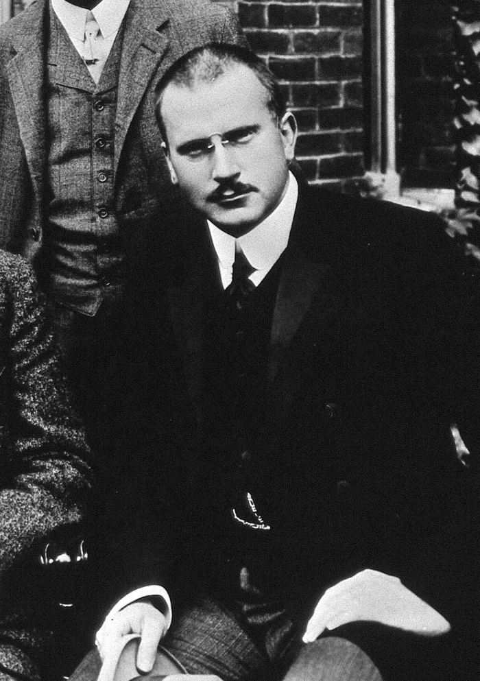 Black-and-white photograph of a young Carl Jung in a dark suit and tie, looking off-camera