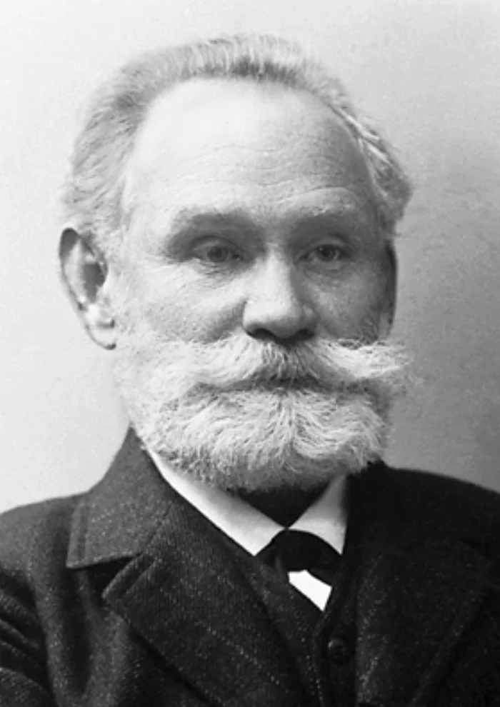 Black-and-white portrait of Ivan Pavlov, an older man with a full white beard and mustache, in a dark suit