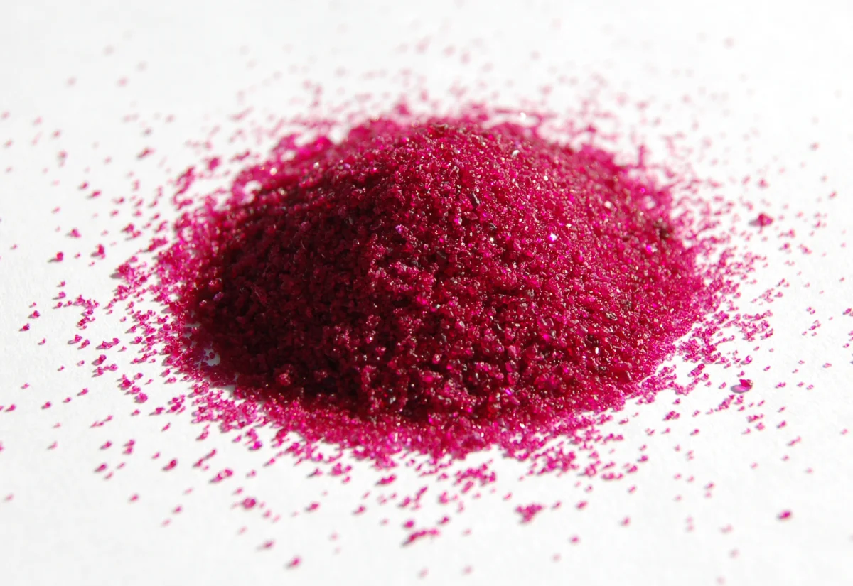 A pile of vivid magenta-pink crystalline powder of cobalt(II) chloride hexahydrate, demonstrating the characteristic bright color of a transition metal compound