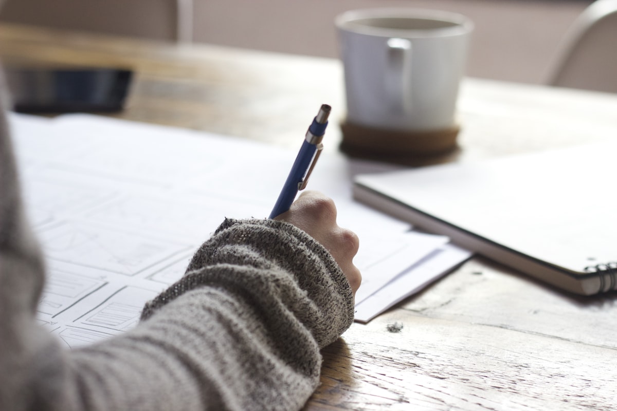 Student studying at a desk with notes and coffee